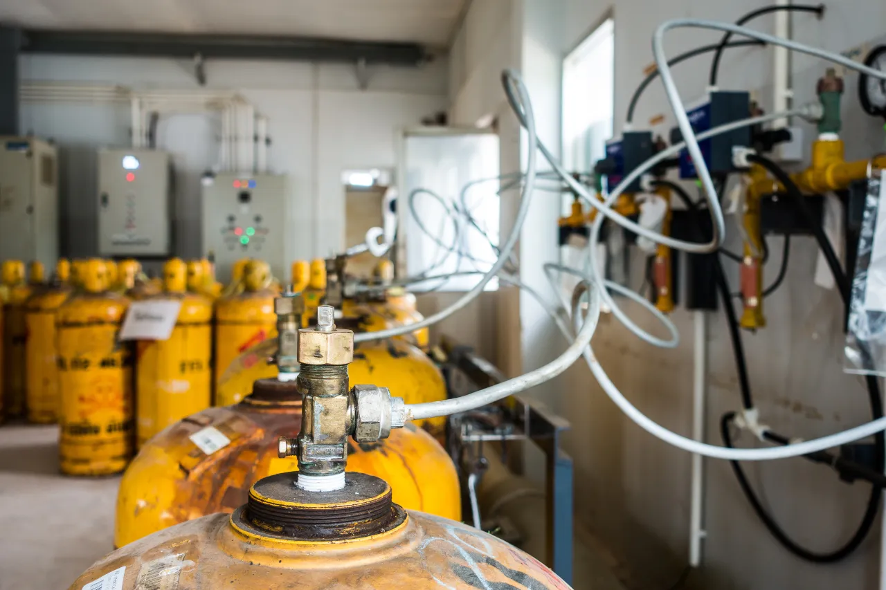 Bombole gialle collegate a impianto di gas industriale