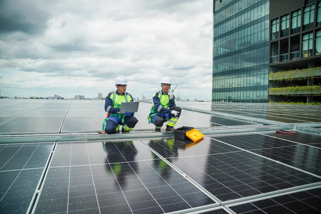Tecnici controllano pannelli solari sul tetto di un edificio