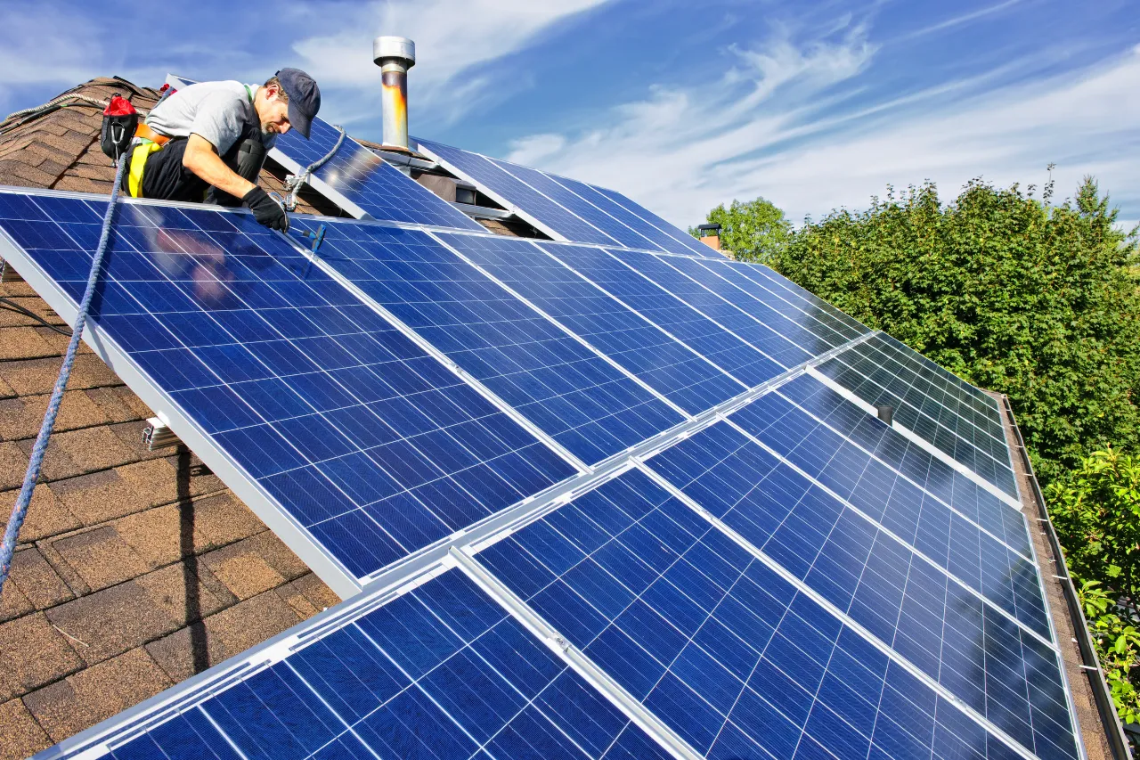 Tecnico installa pannelli solari su tetto residenziale