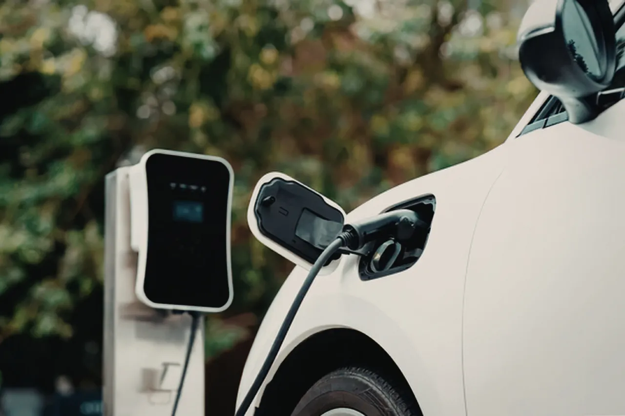 Auto elettrica bianca in ricarica presso colonnina