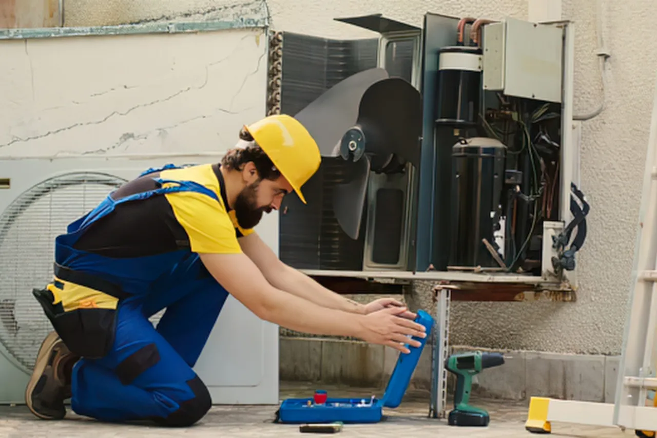 Tecnico ripara un condizionatore esterno con strumenti