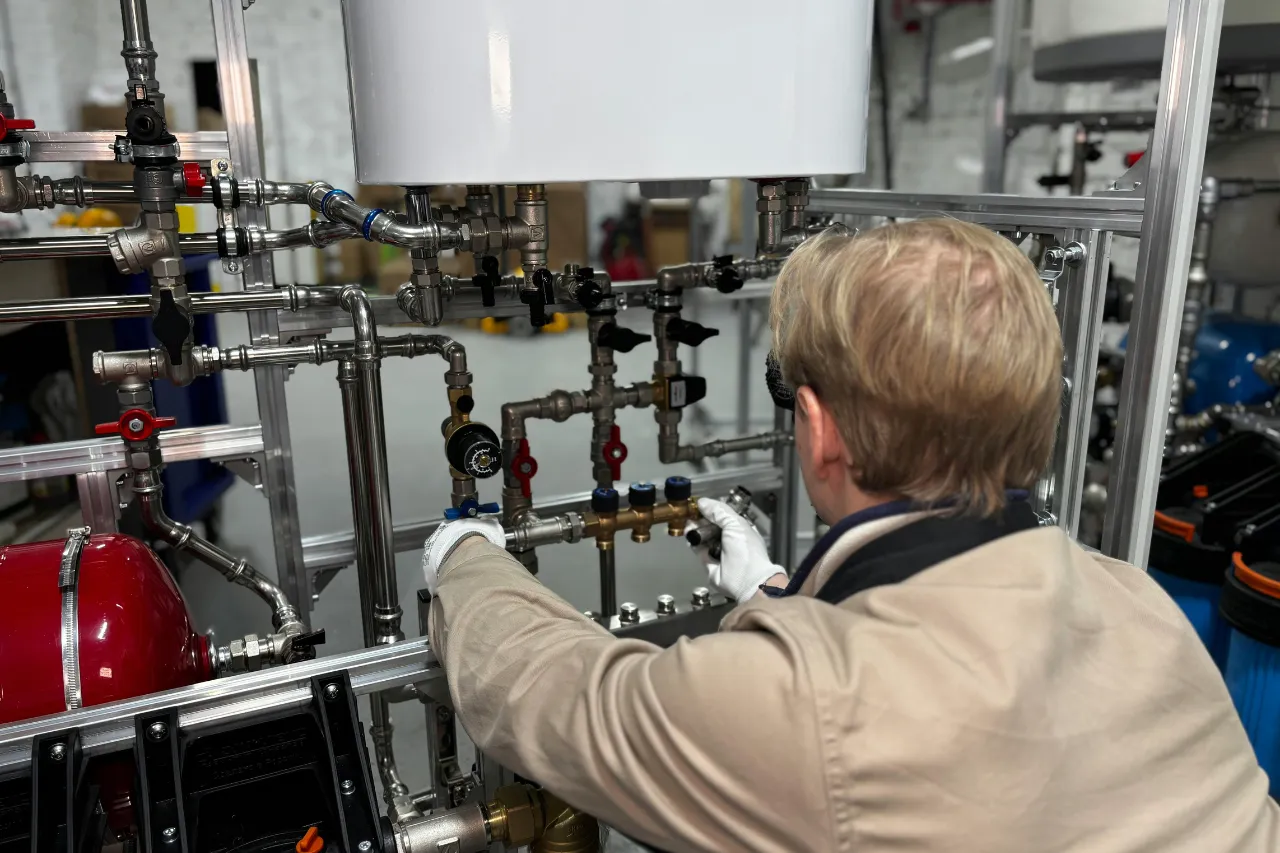 Tecnico regola valvole di un impianto idraulico industriale