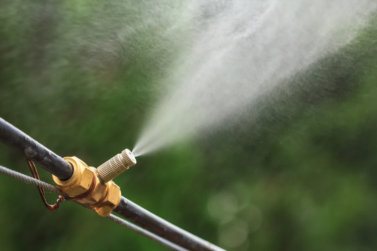 Ugello nebulizzatore spruzza acqua su sfondo verde