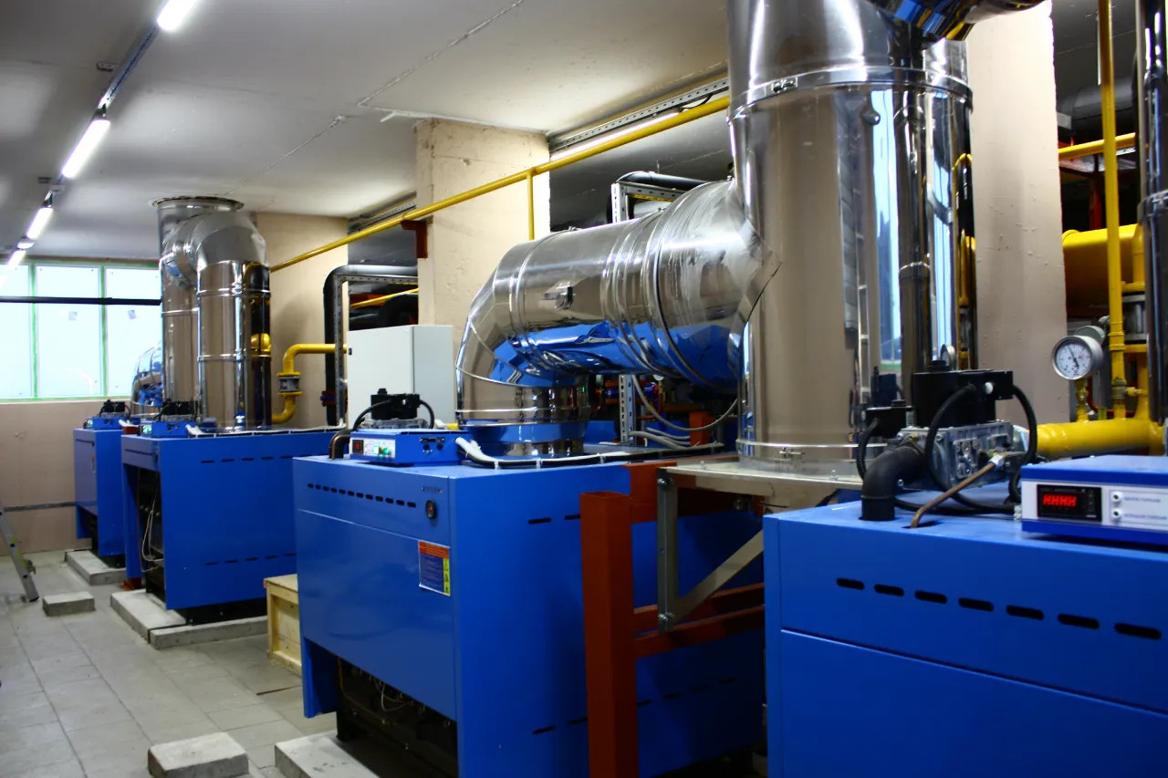 Impianto termico industriale con caldaie blu e tubazioni metalliche