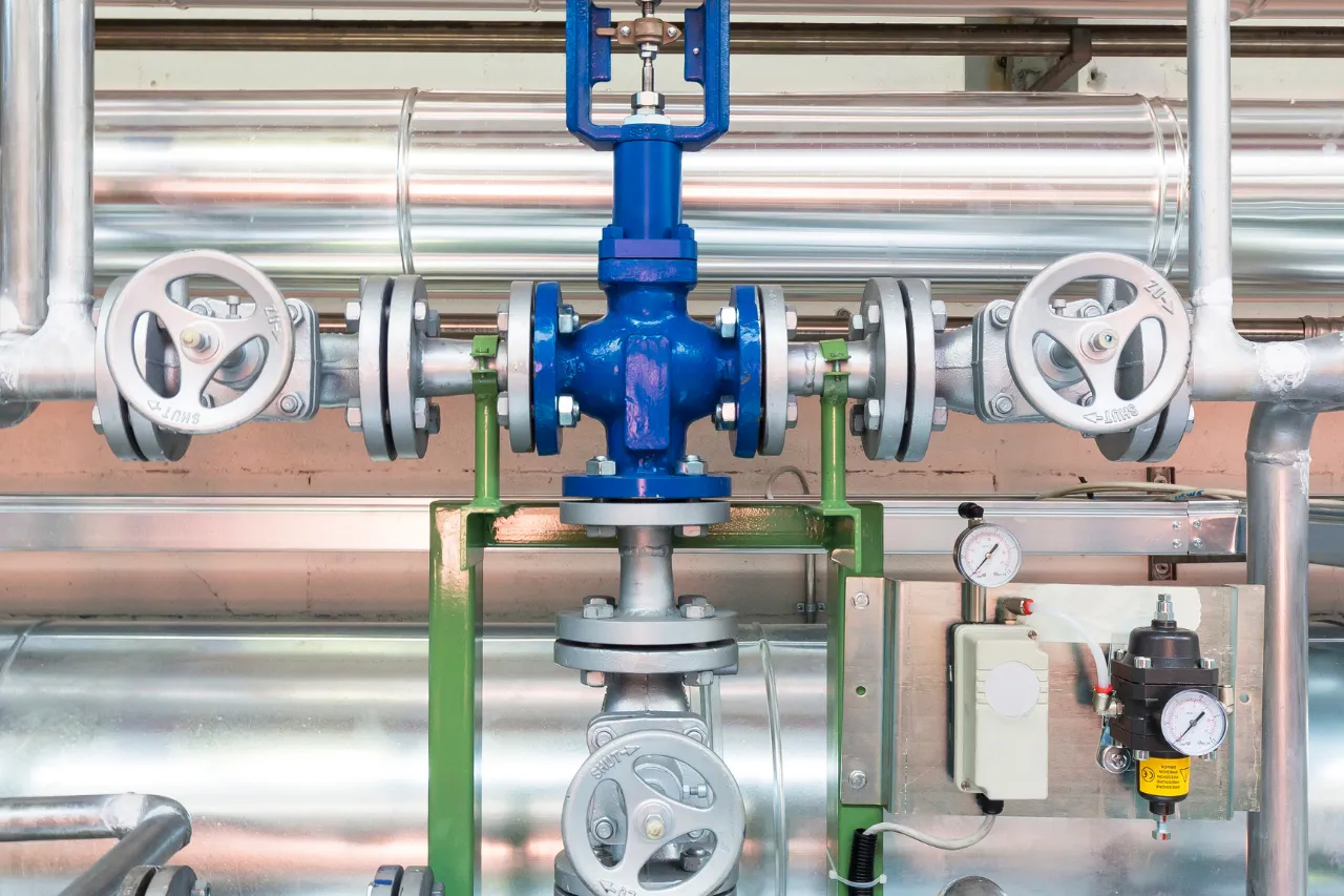 Valvole industriali su tubazioni metalliche con manometri