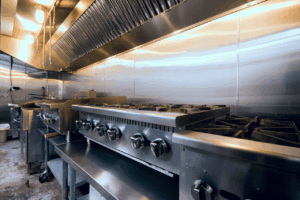 Cucina professionale con fornelli industriali e cappa inox