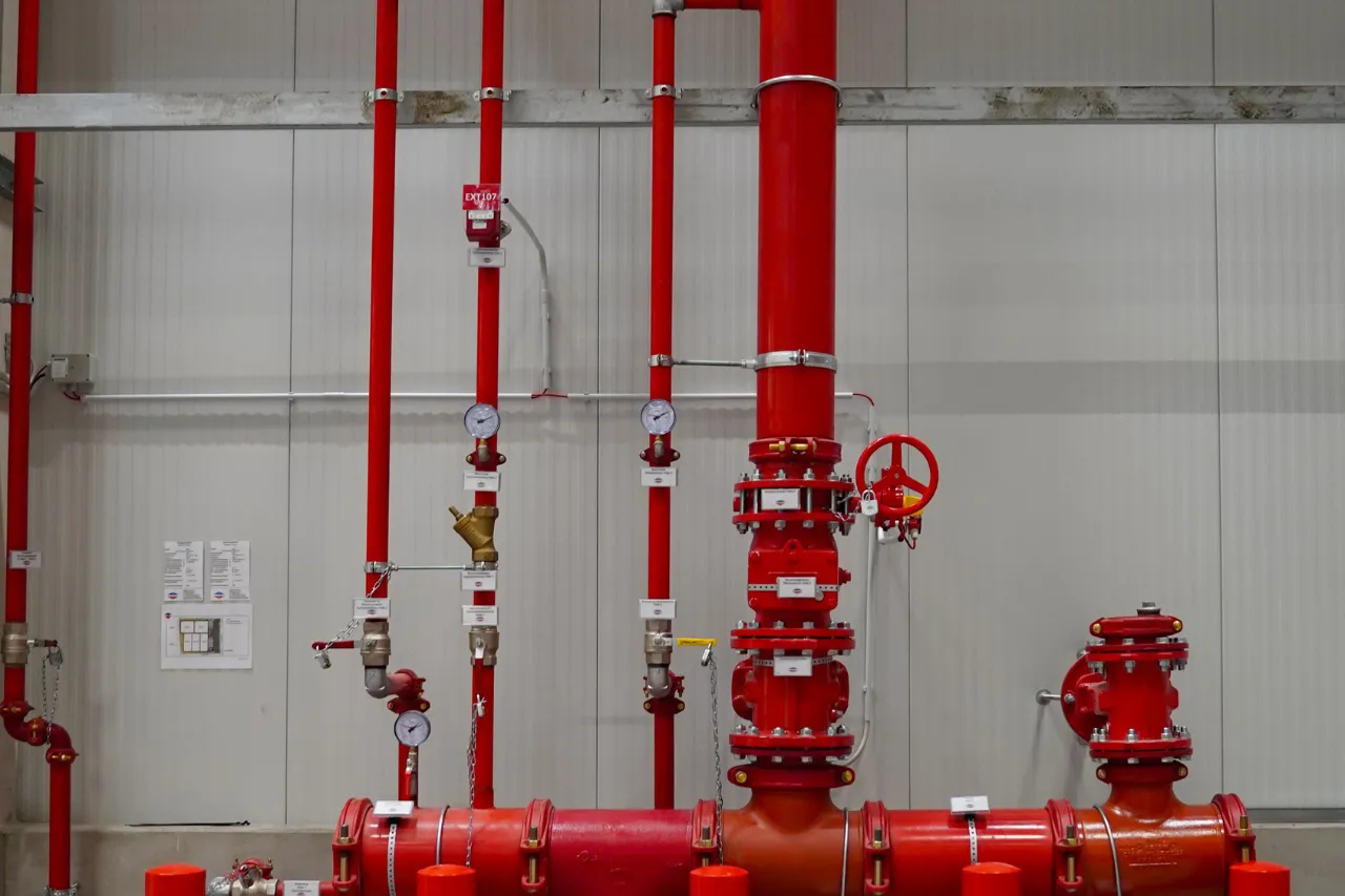 Tubazioni antincendio rosse con valvole e manometri industriali