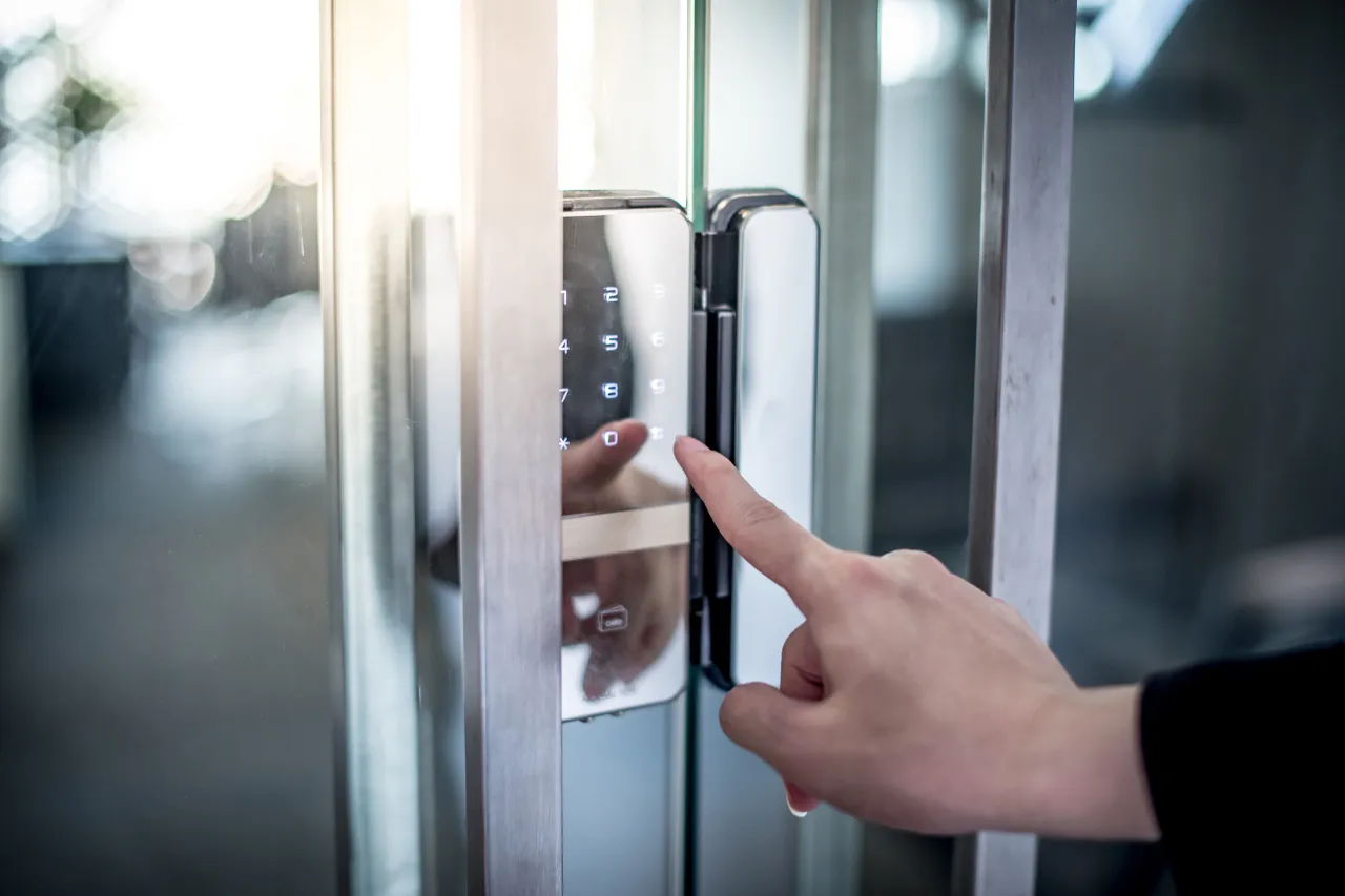 Mano inserisce codice su serratura elettronica di porta