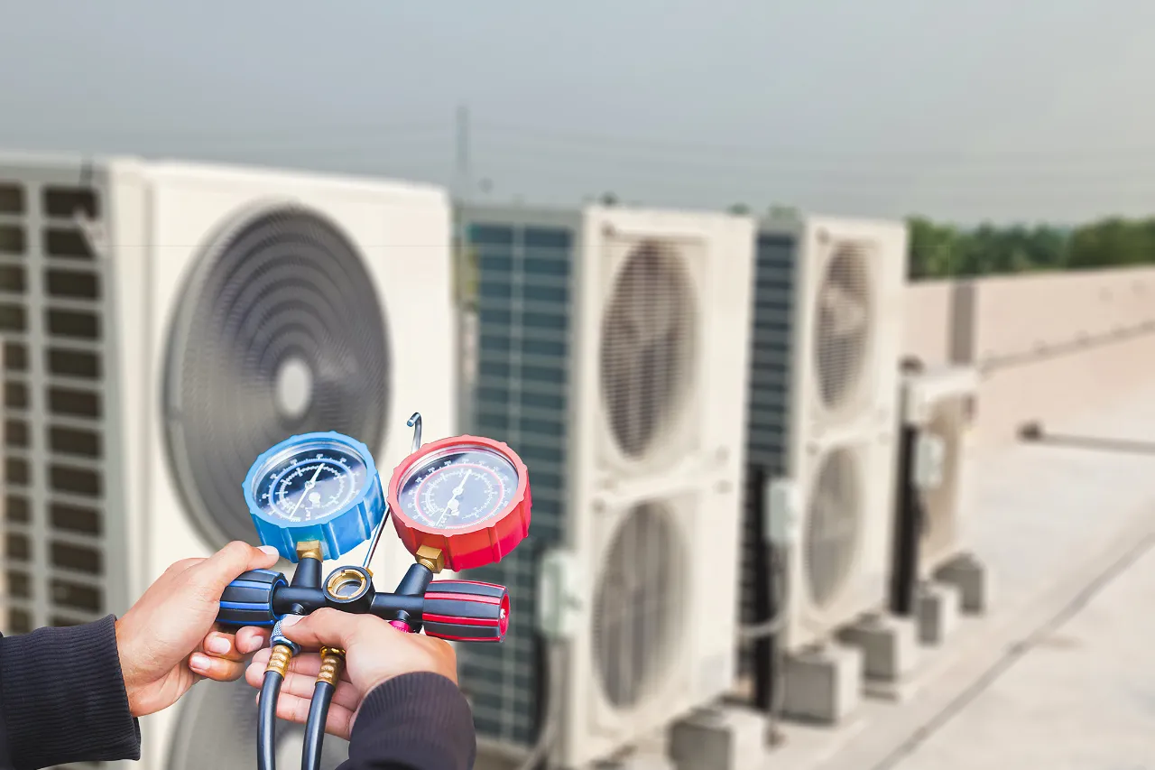 Tecnico controlla manometri su unità esterne di climatizzazione