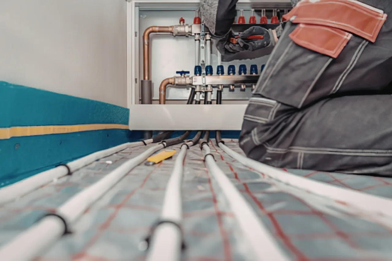 Tecnico installa collettore per impianto di riscaldamento a pavimento