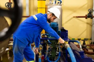 Tecnico regola una valvola in un impianto industriale