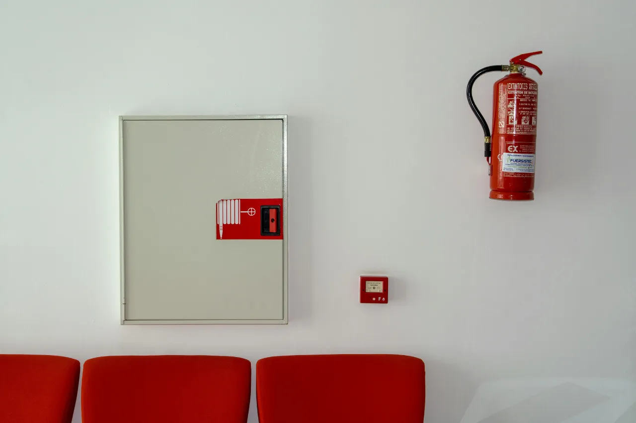 Estintore e armadio antincendio su parete bianca