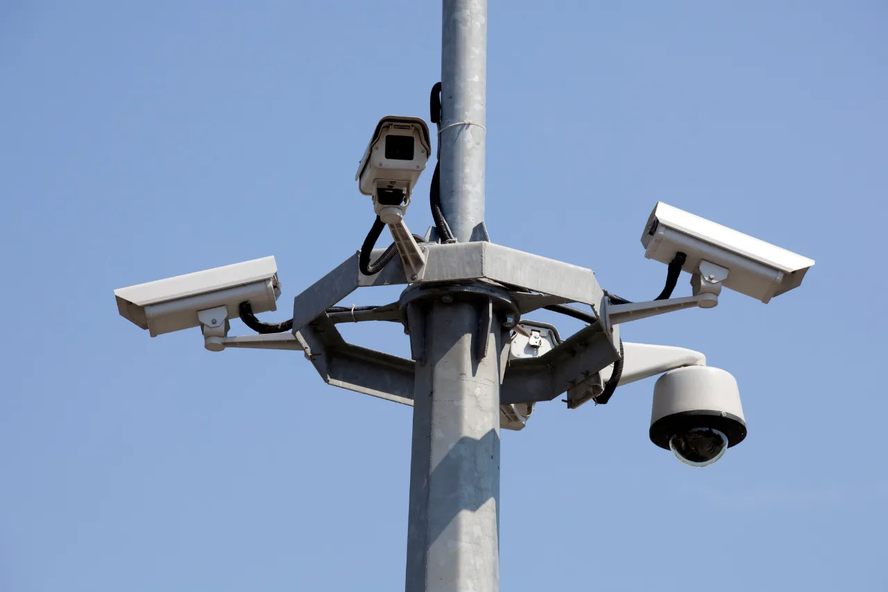 Telecamere di sorveglianza su palo contro cielo azzurro