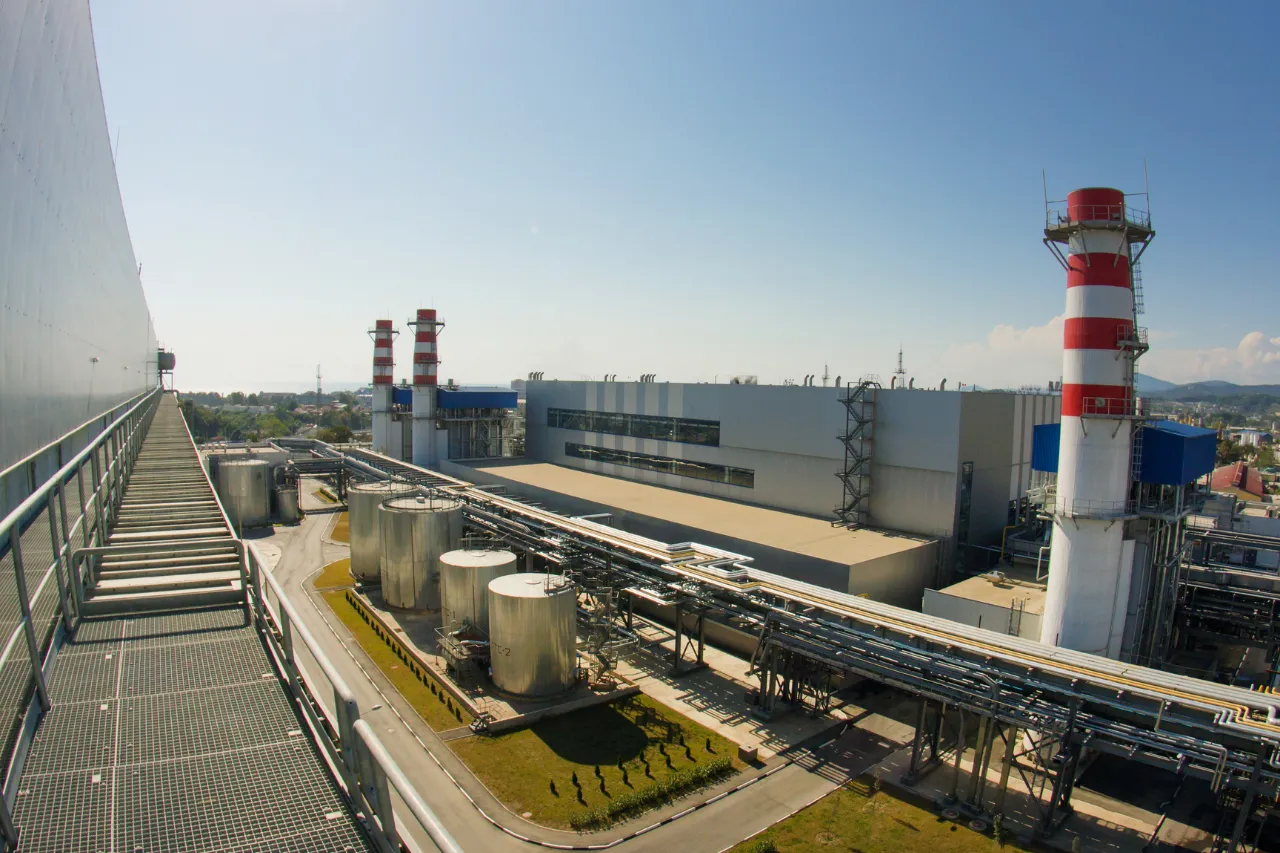 Impianto industriale con serbatoi, tubazioni e ciminiere