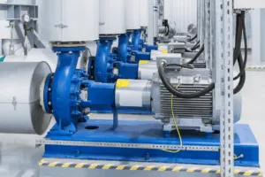 Pompe industriali blu con motori elettrici in sala tecnica