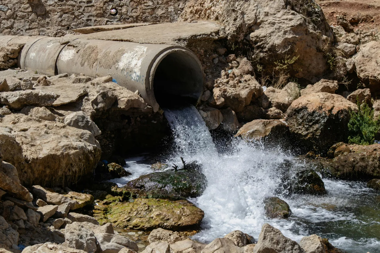Acqua fuoriesce da un tubo tra rocce