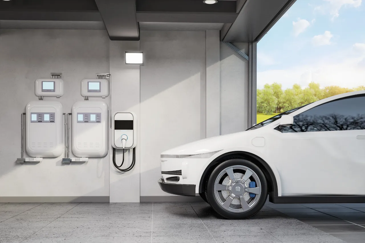 Auto elettrica bianca accanto a stazione di ricarica domestica