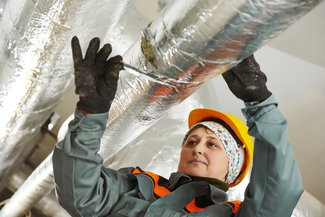 Tecnica installa isolamento su condotta industriale