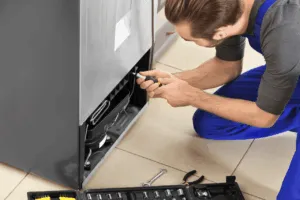 Tecnico ripara il retro di un frigorifero