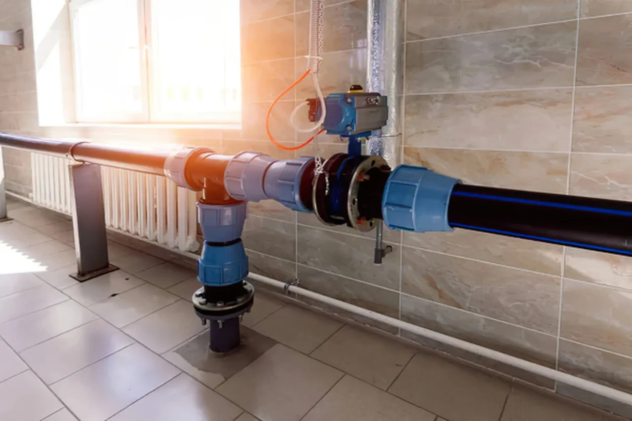 Tubazioni idriche con valvola industriale in locale tecnico