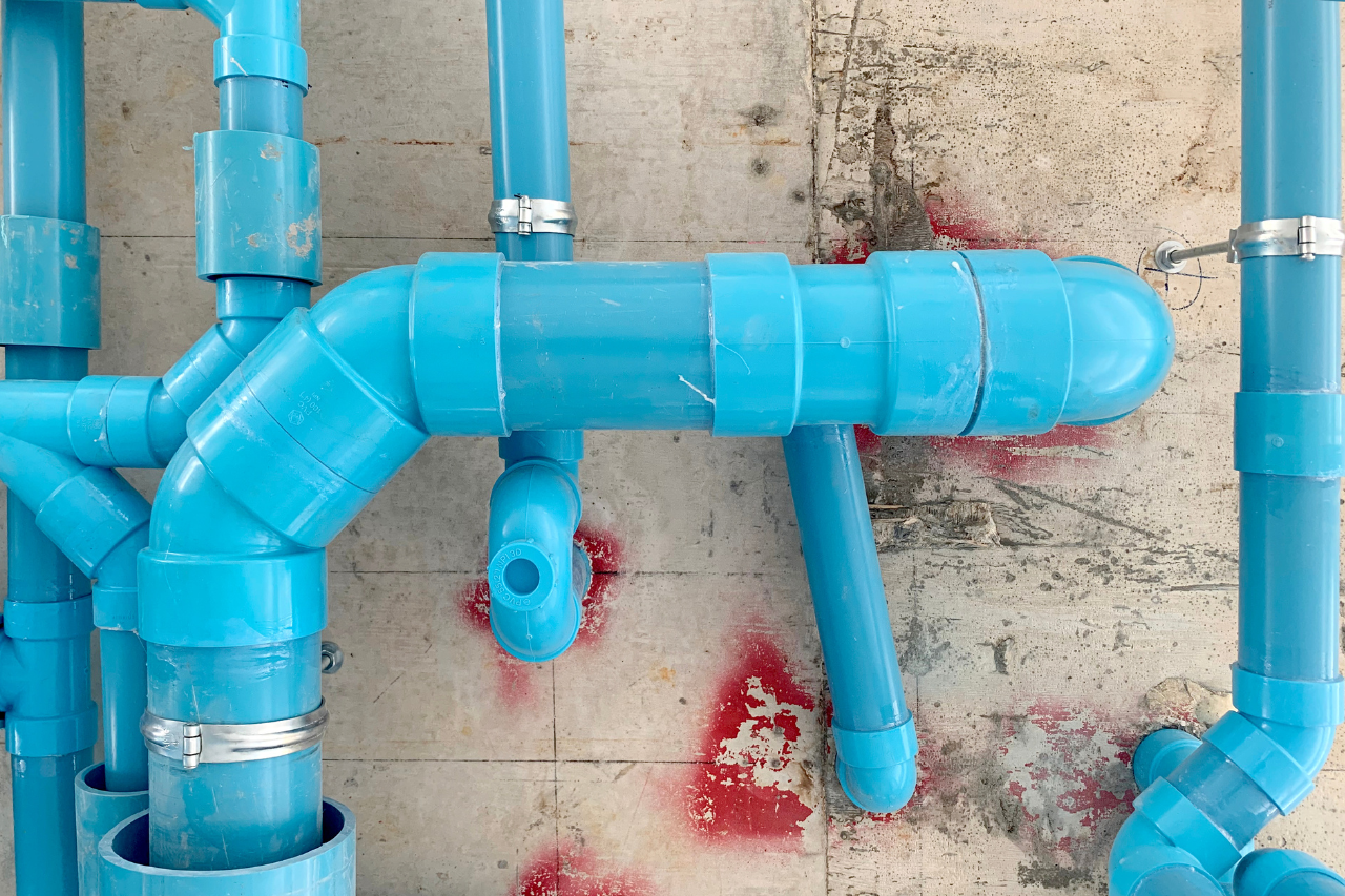 Tubazioni blu in PVC su parete di cemento