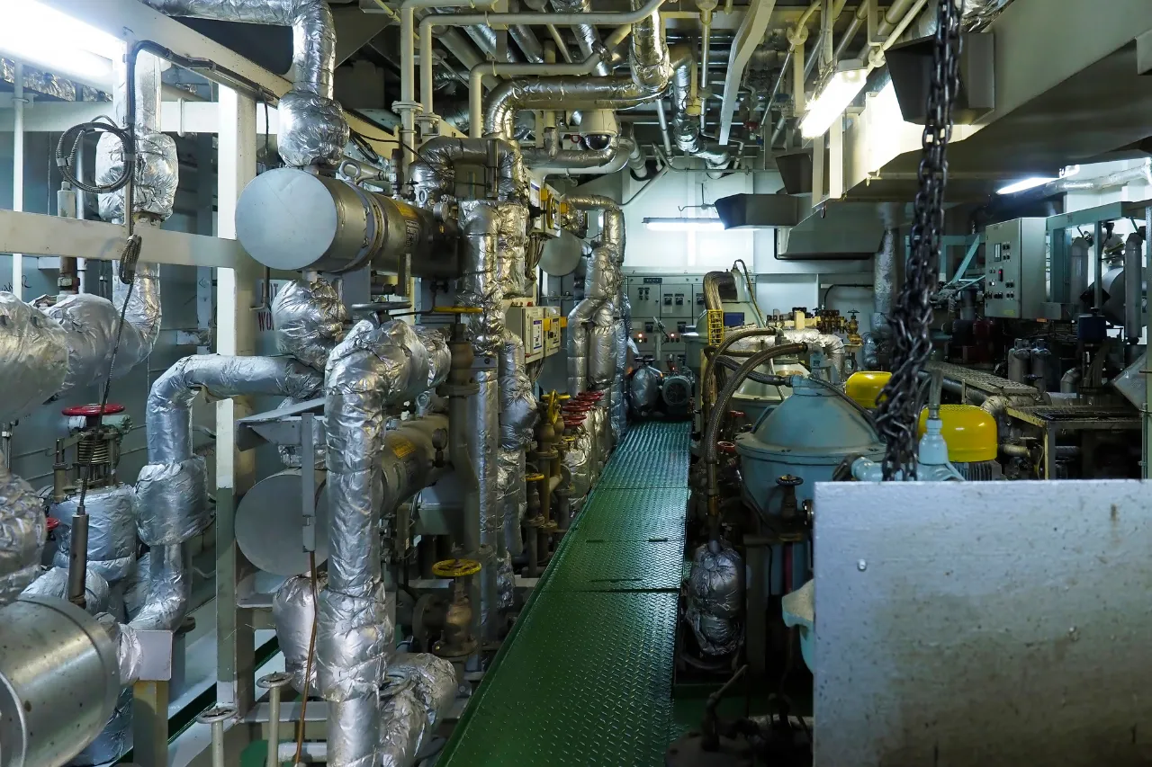 Sala macchine industriale con tubazioni isolate e pannelli di controllo
