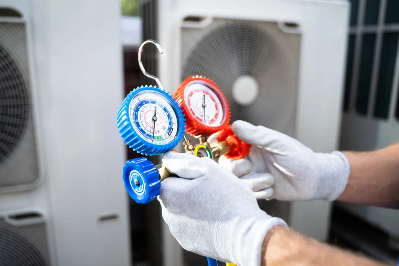 Tecnico controlla manometro di un impianto di climatizzazione
