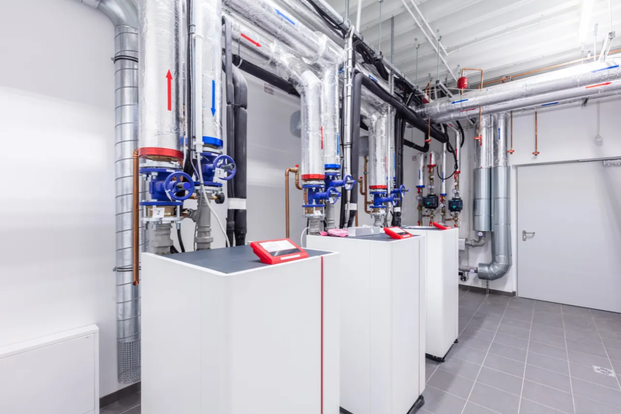Locale tecnico con tubazioni isolate e caldaie industriali