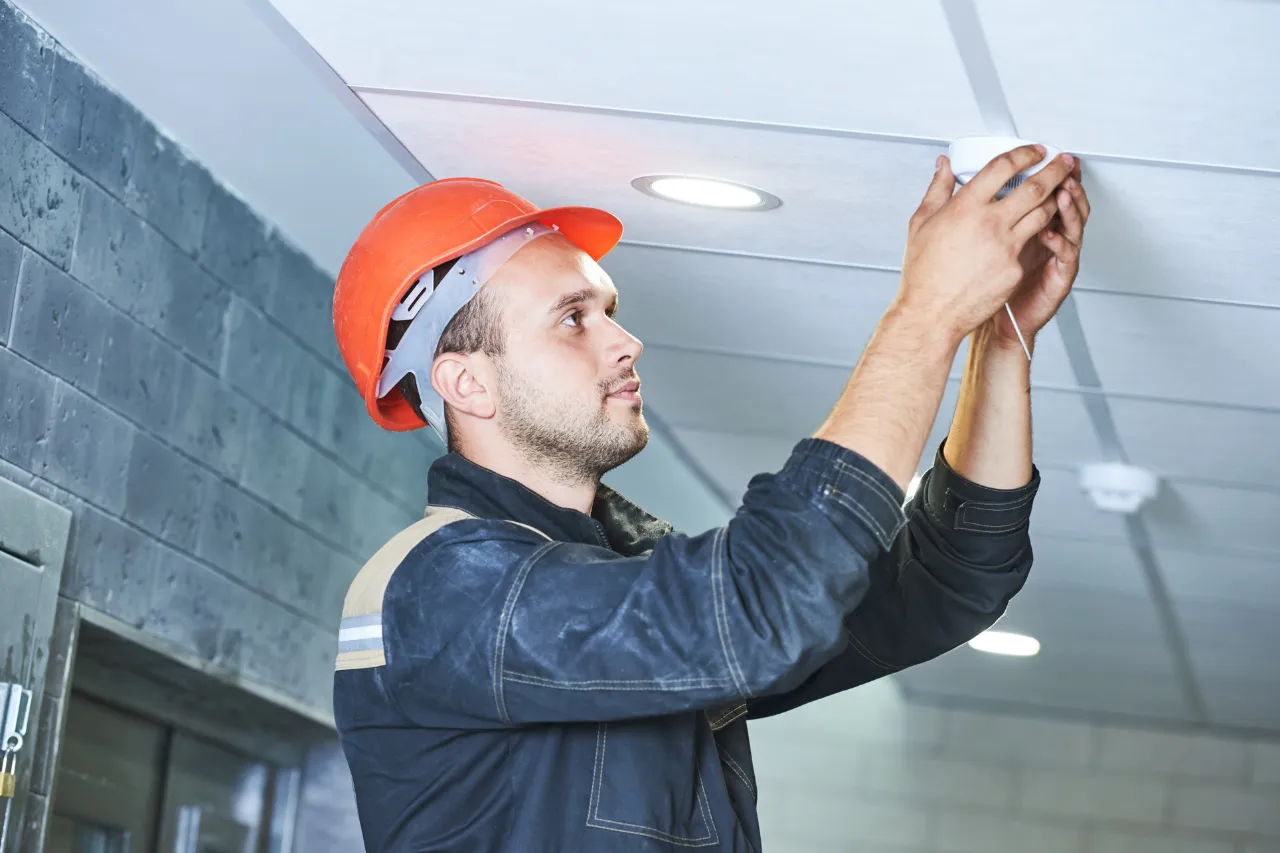 Tecnico installa un rilevatore di fumo sul soffitto