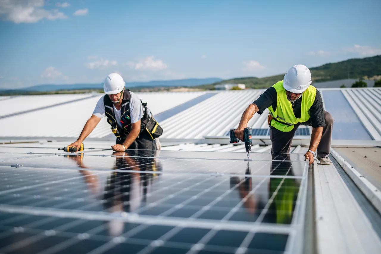 Tecnici installano pannelli solari su tetto industriale