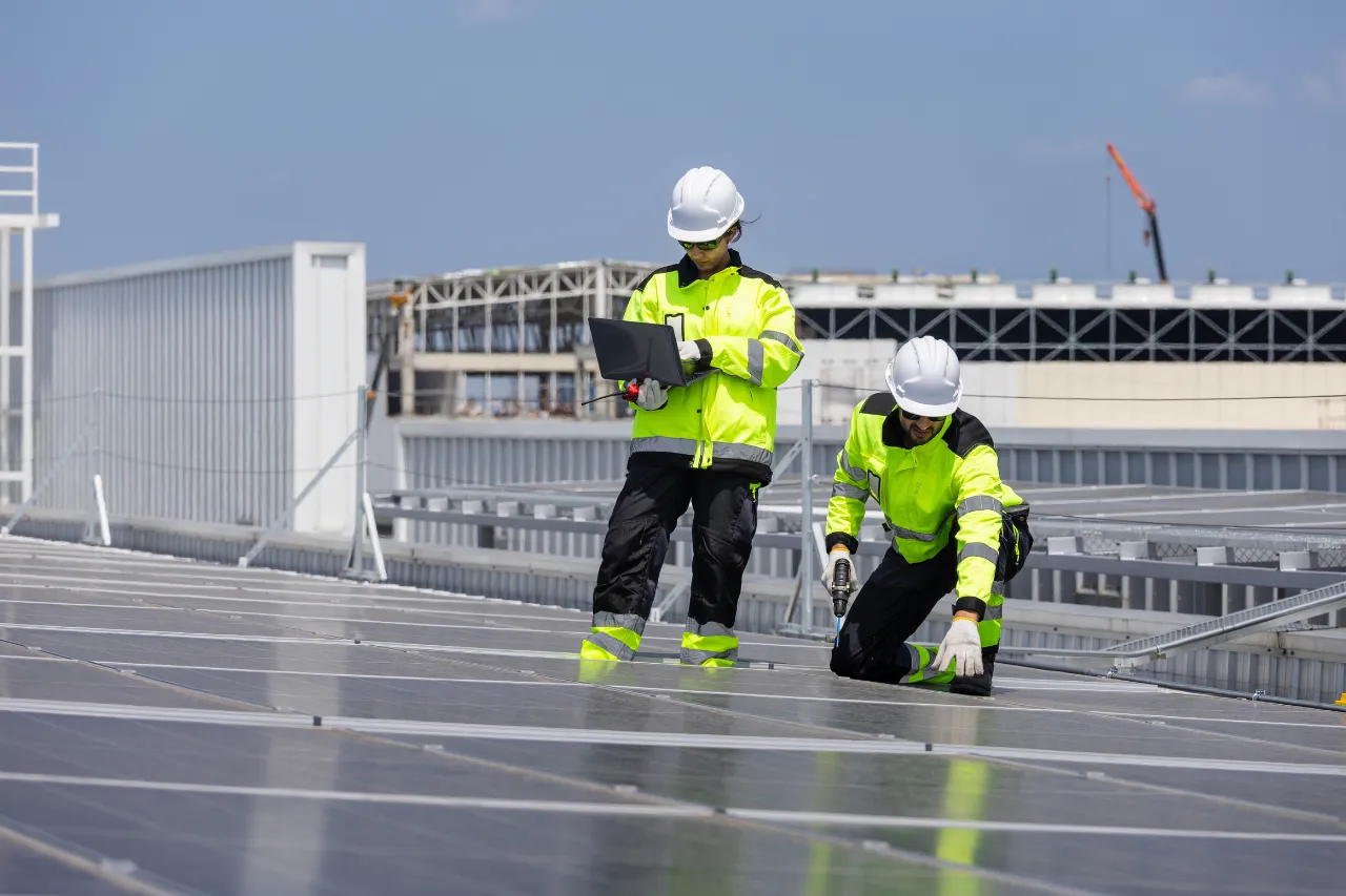Tecnici installano pannelli solari su tetto industriale