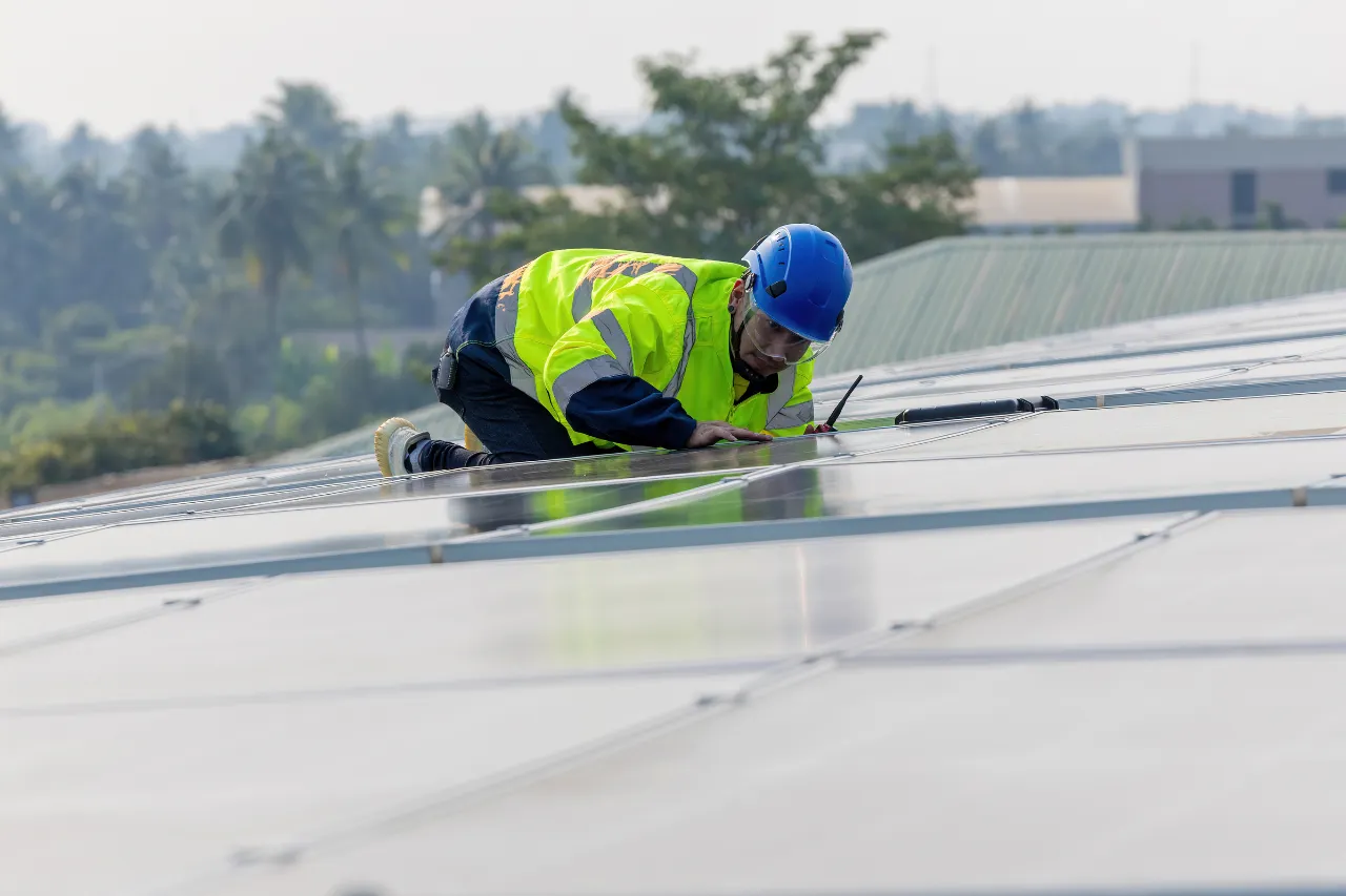 Tecnico installa pannelli solari su un tetto industriale