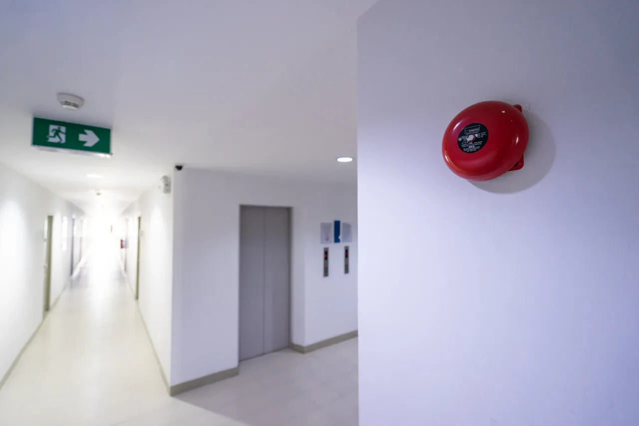 Campanello antincendio in corridoio con ascensore e uscita