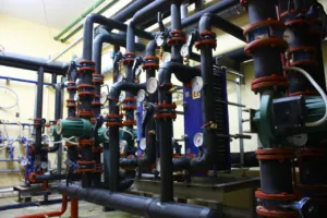 Impianto idraulico industriale con tubazioni, pompe e manometri