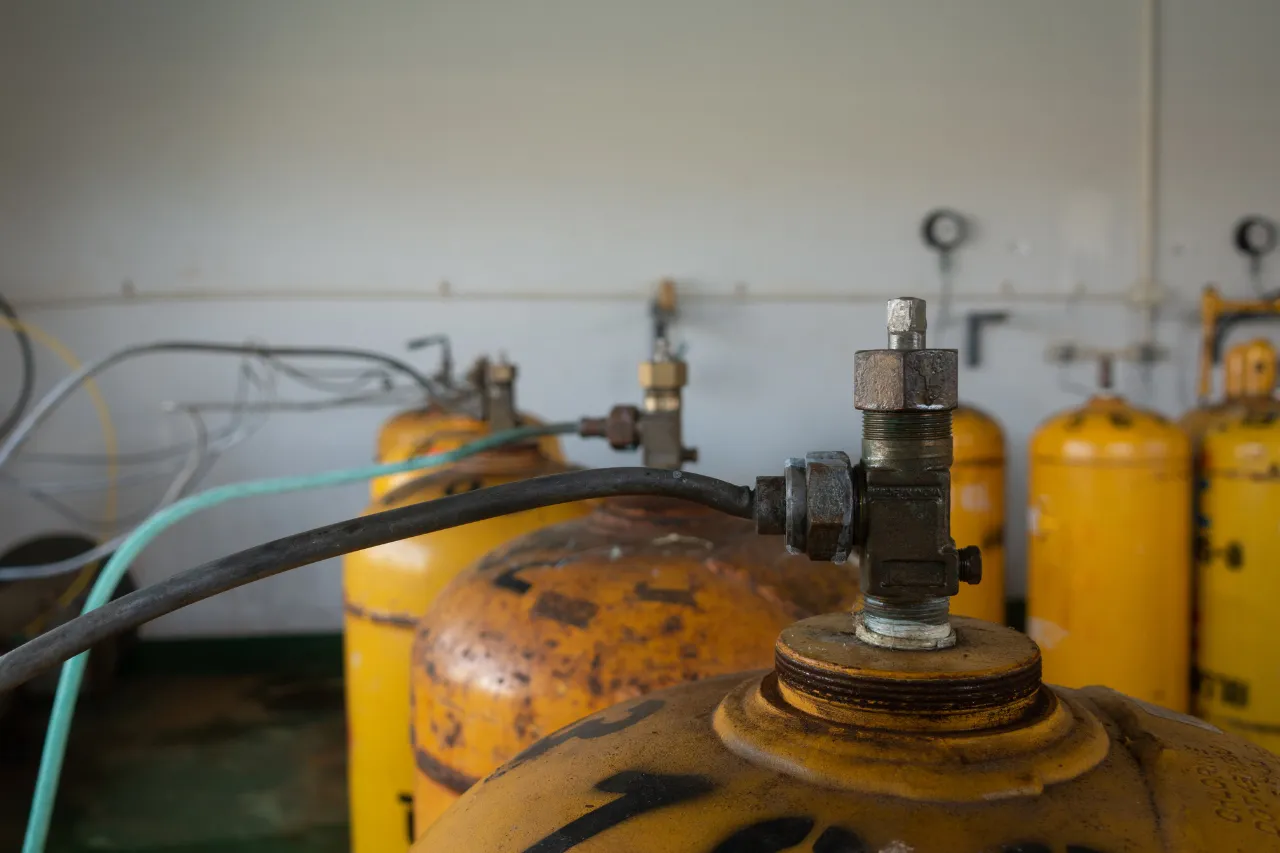 Bombole gialle di gas con valvole e tubi