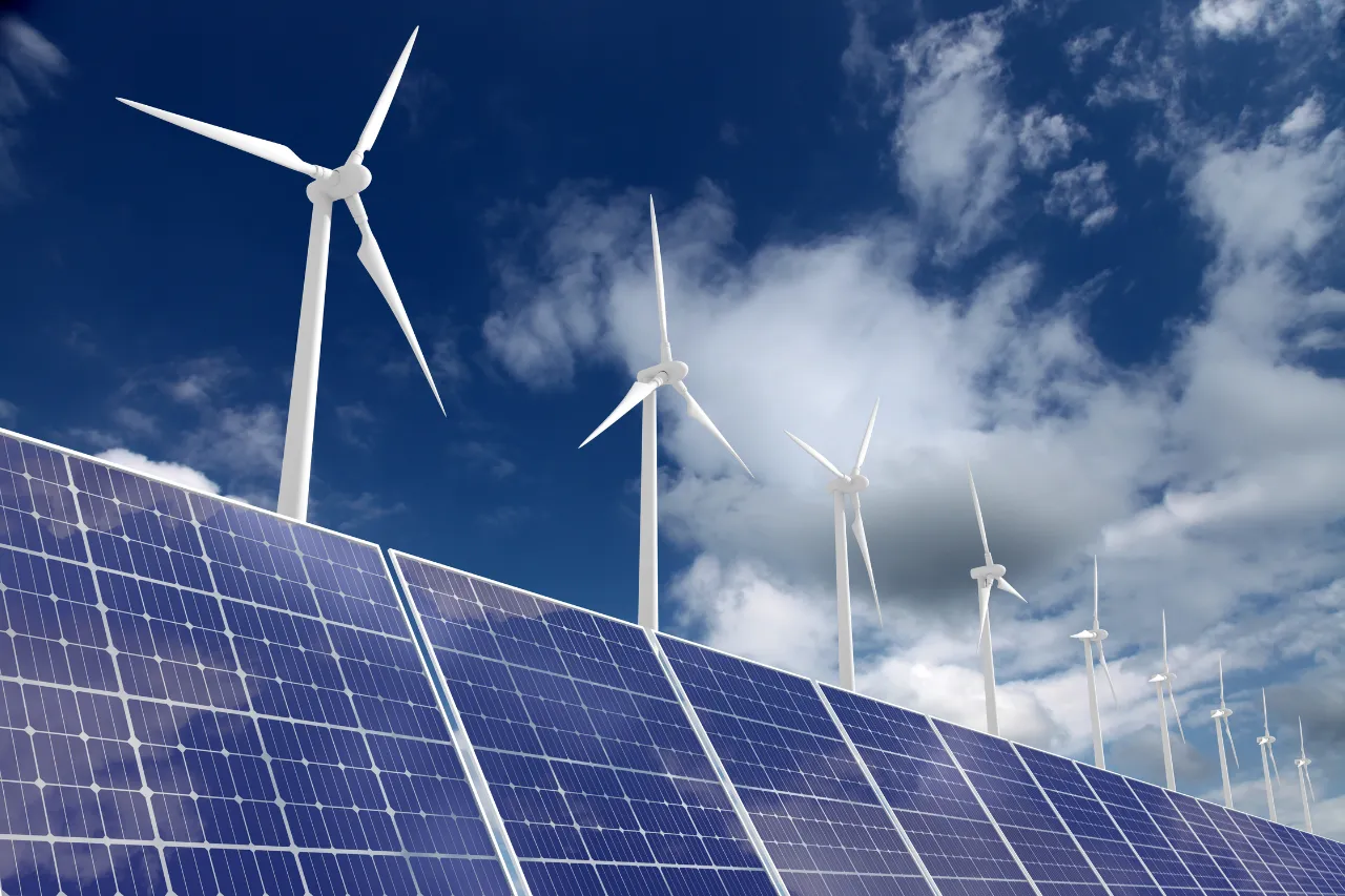Pannelli solari e turbine eoliche sotto cielo nuvoloso