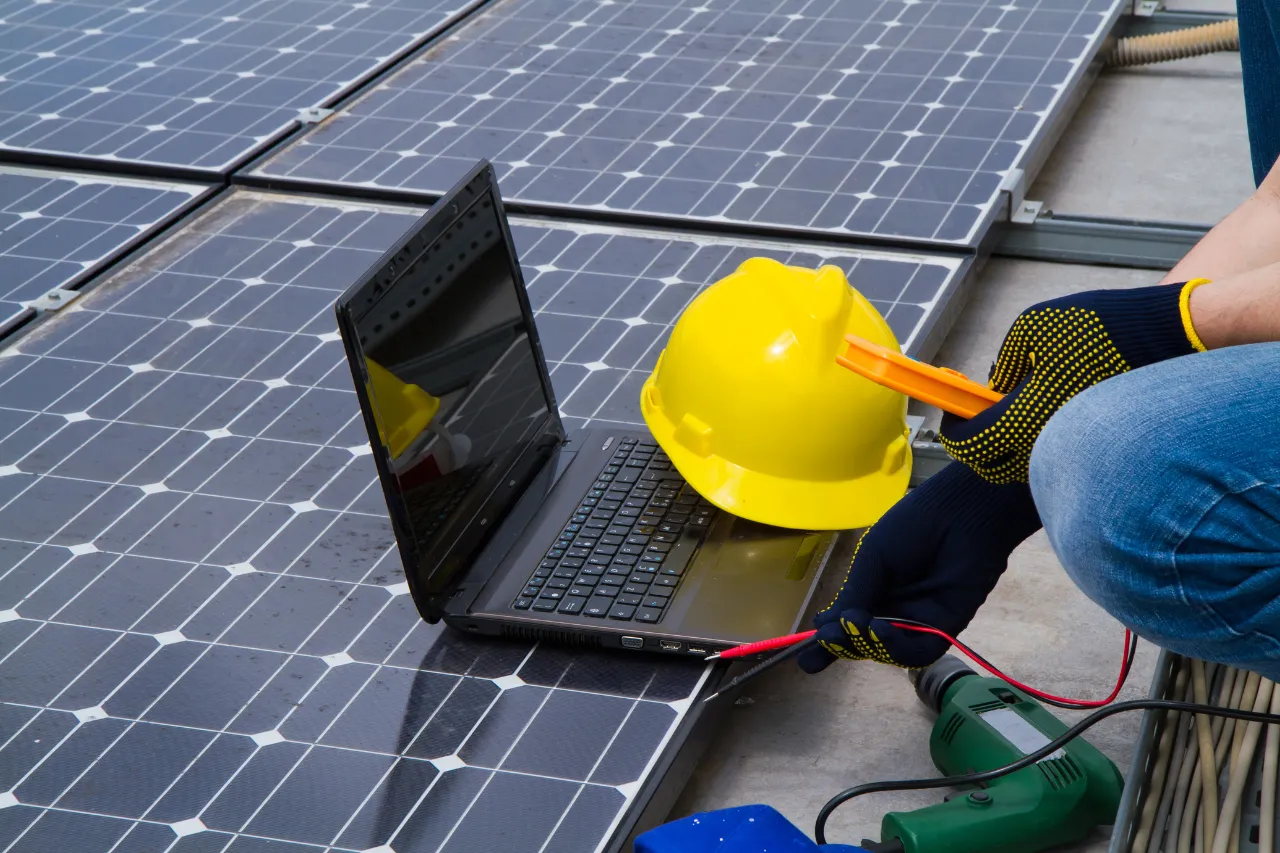 Tecnico verifica pannelli solari con laptop e strumenti