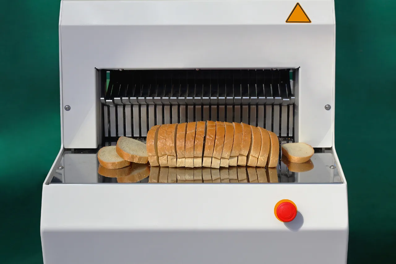 Affettatrice industriale con pagnotta di pane tagliata