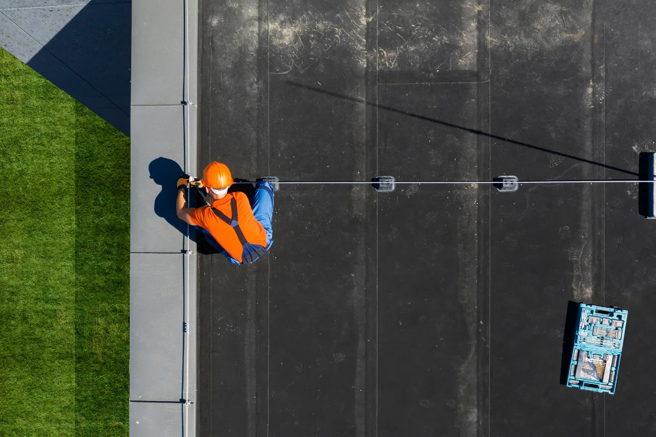 Operaio con casco arancione su tetto