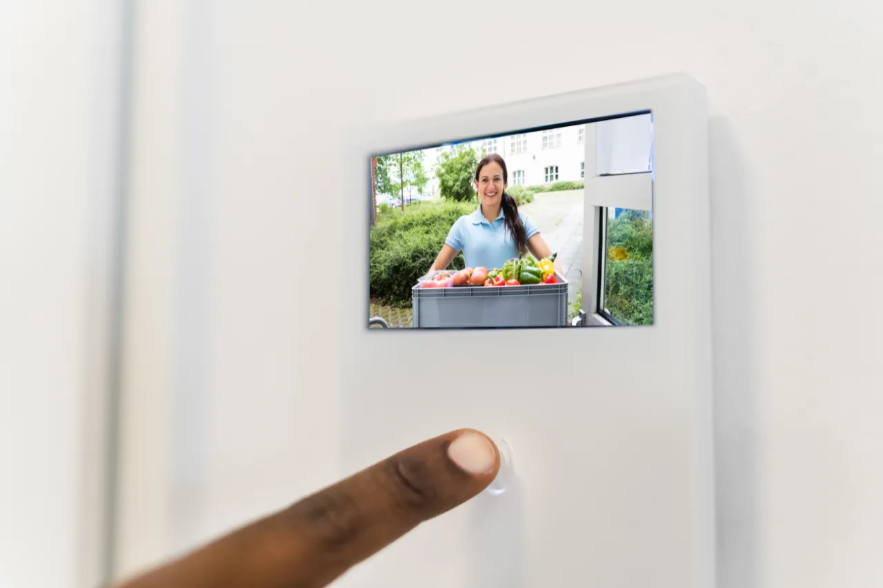 Donna consegna spesa al videocitofono moderno