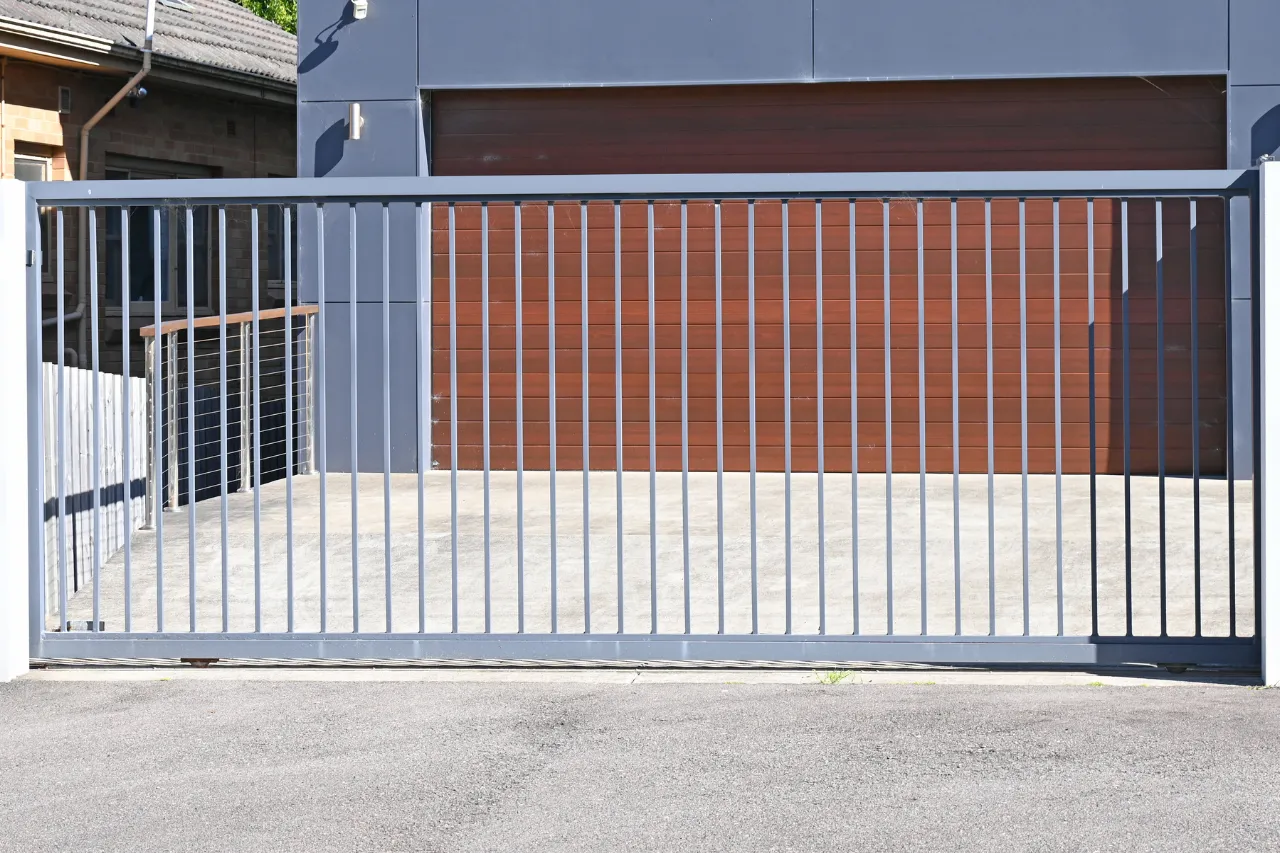 Cancello scorrevole moderno davanti a garage in legno