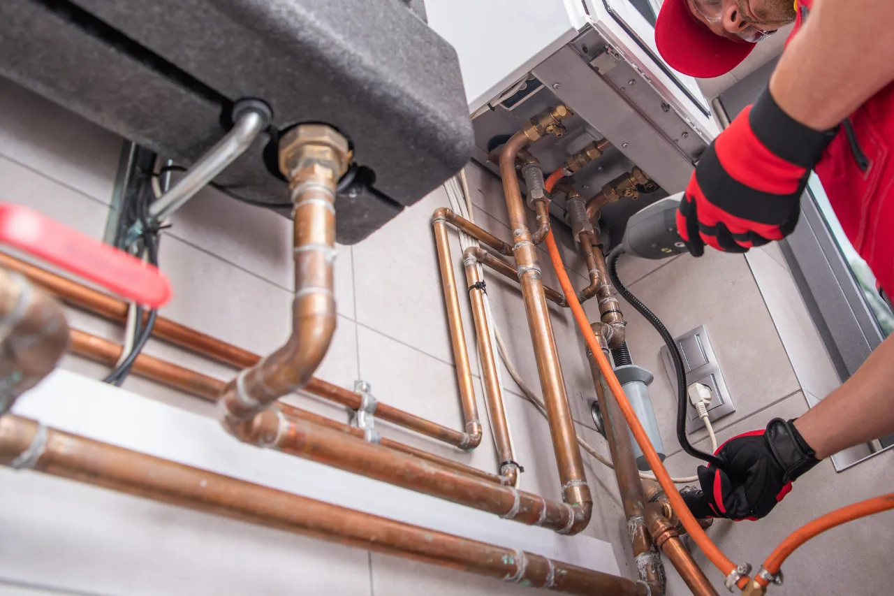 Tecnico controlla caldaia e tubature di rame