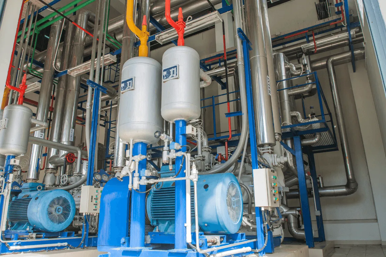 Impianto industriale con pompe, serbatoi e tubazioni colorate