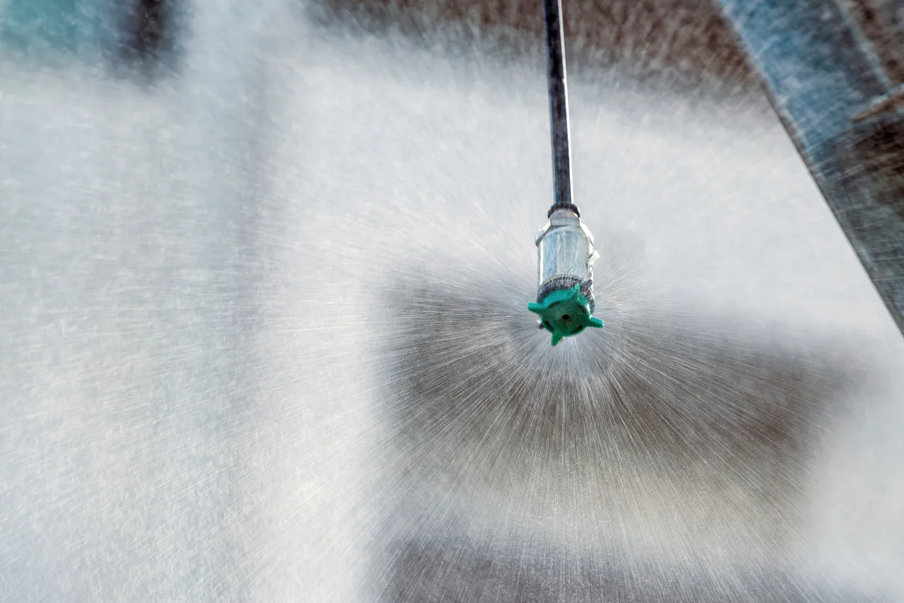 Ugello nebulizzatore spruzza acqua su superficie metallica