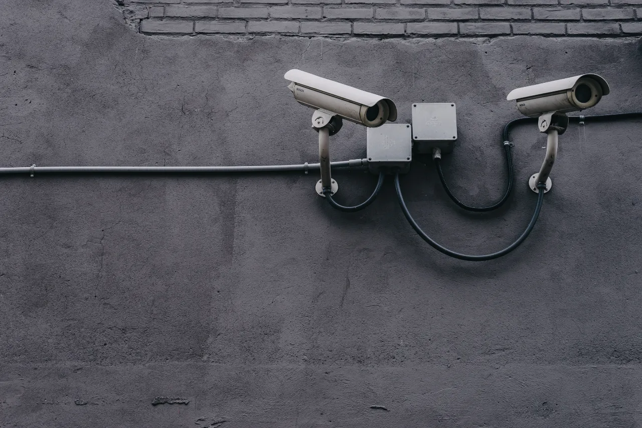 Due telecamere di sorveglianza su muro grigio