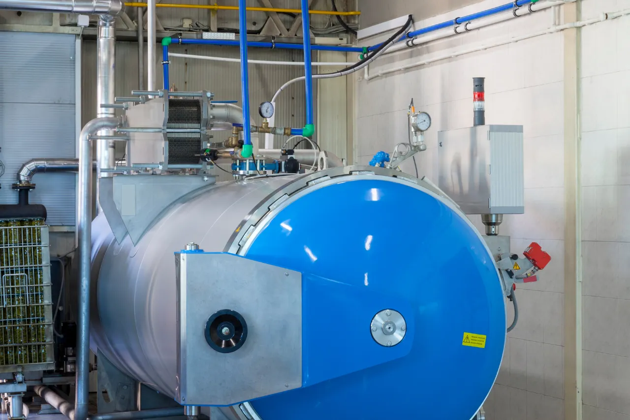 Autoclave industriale blu con tubazioni e manometri