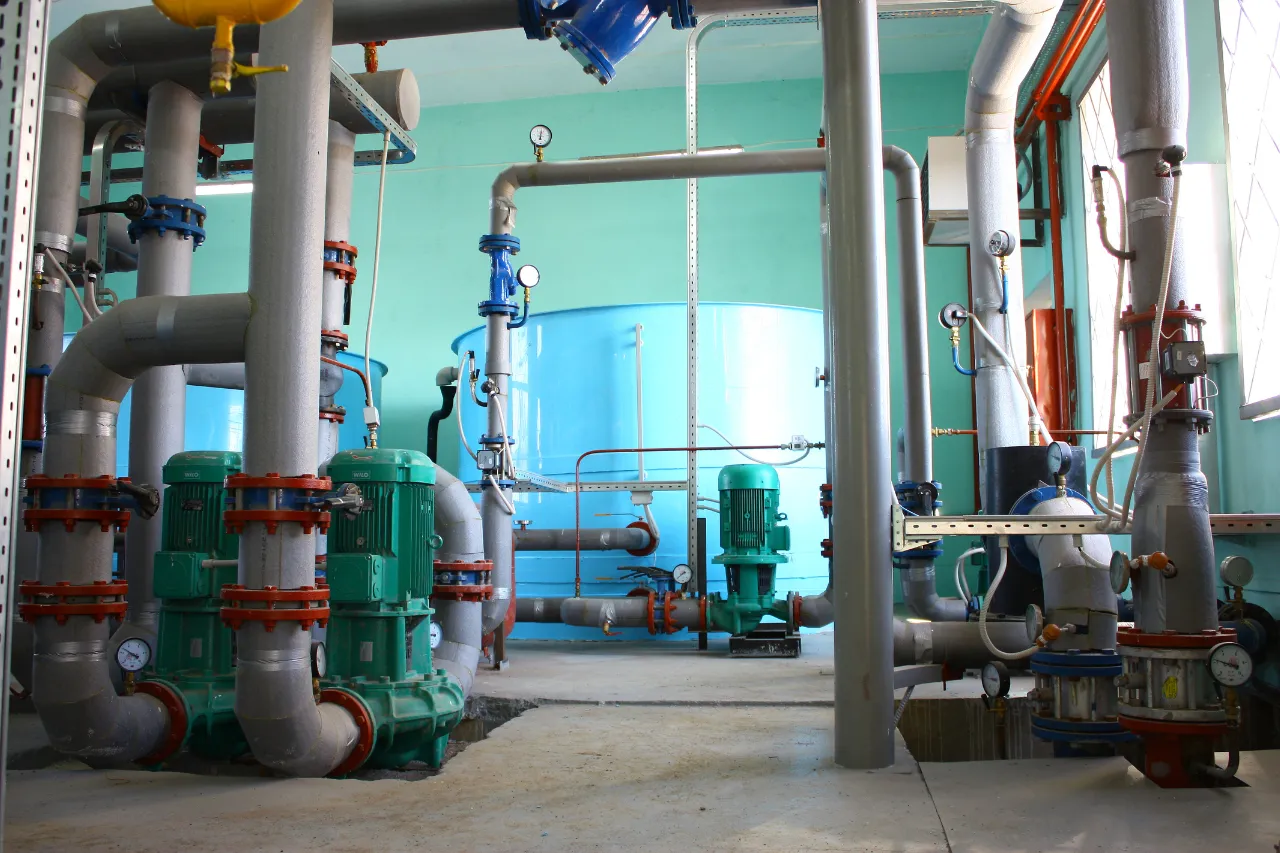 Impianto industriale con pompe, tubazioni e serbatoi blu