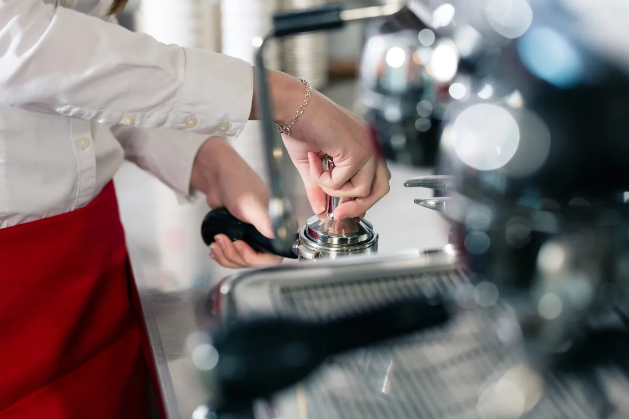 Barista pressa il caffè con tamper professionale