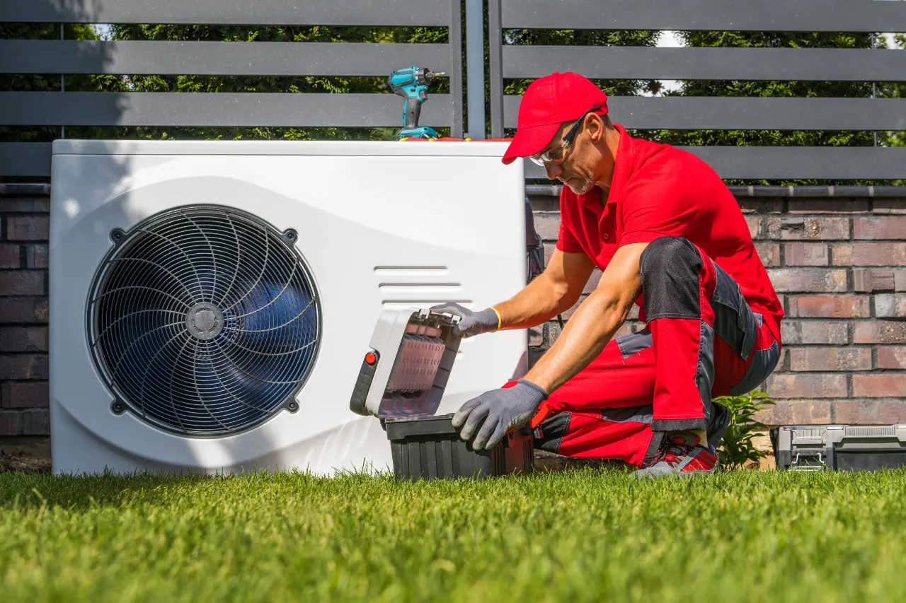 Tecnico manutiene unità esterna di pompa di calore
