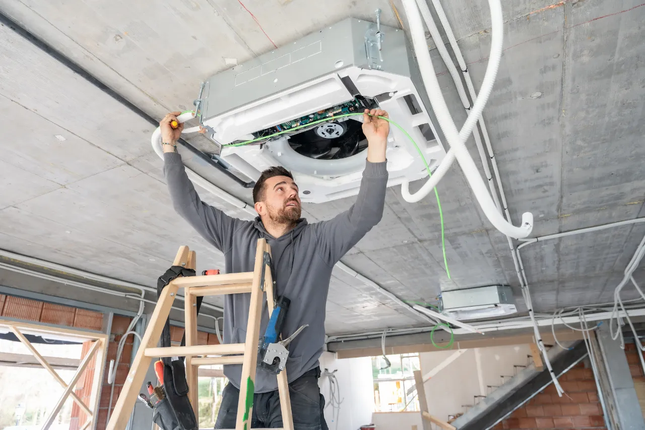 Tecnico installa un condizionatore a soffitto